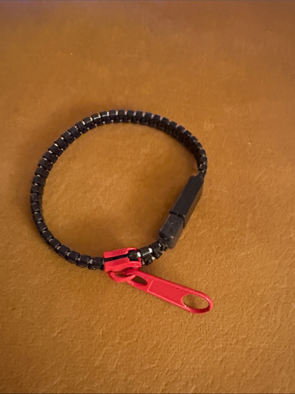 Women’s black and red zipper bracelet.
